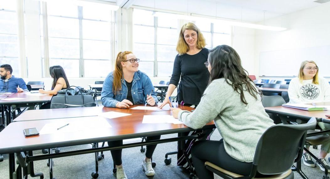 students interact with professor in classroom